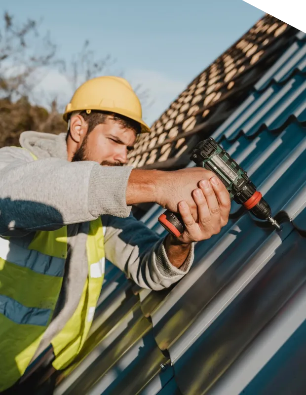 Worker drilling on metal roof