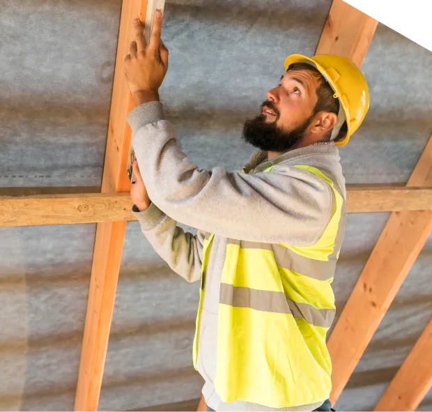 Construction worker inspecting wooden beams on site